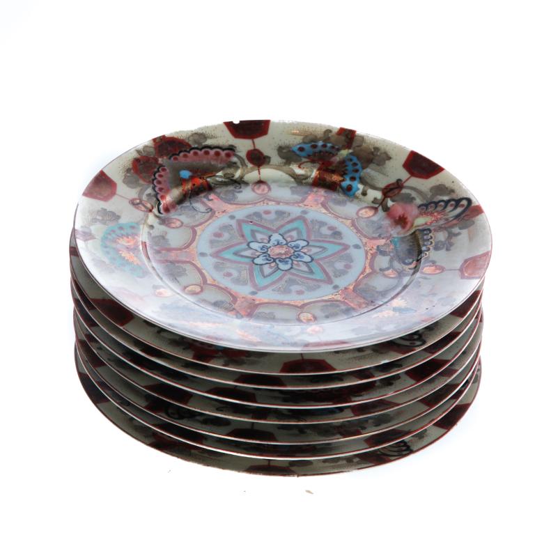 EIGHT JAPANESE KUTANI BUTTERFLY PLATES.: Meiji perioed, late 19th- early 20th century, porcelain. Hand decoration with butterfly borders. Red three character marks on the underside. Minor wear. 9.25"d.