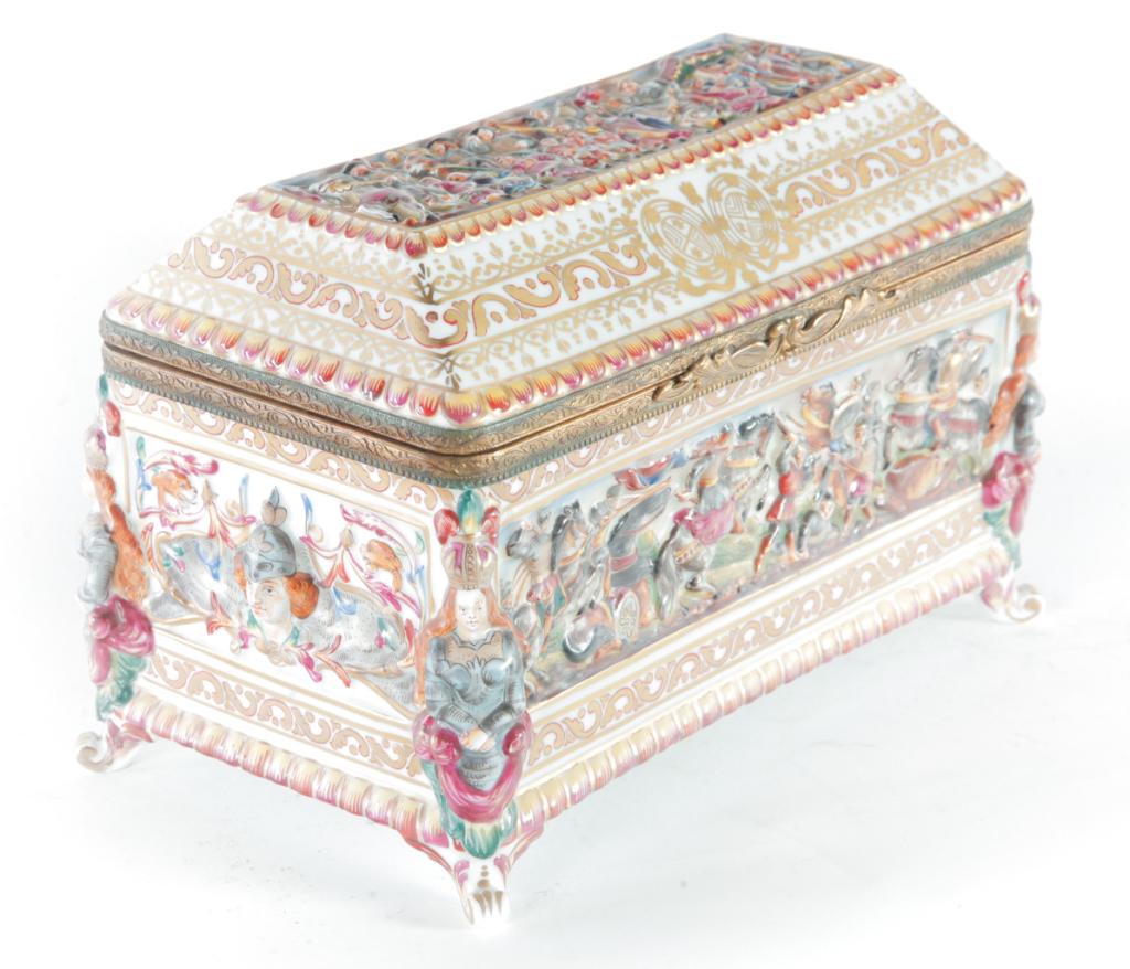 CAPO DI MONTE JEWEL CASKET.: Italy, 19th century. Lid with canted sides. Top of lid and sides have Medieval battle scenes and Joan of Arc at center. 7"h. 10.5"w. 6"d.