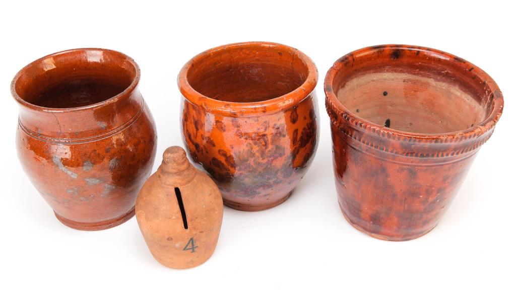 FOUR PIECES OF AMERICAN REDWARE.: First half 19th century. Unglazed bell shaped bank "The Lord Loven, A Cheerful Given", 4.5"h., flower pot with mottled glaze and coggled rim. Cracks and repair, 5.5"h., bulbous jar with turned lines.