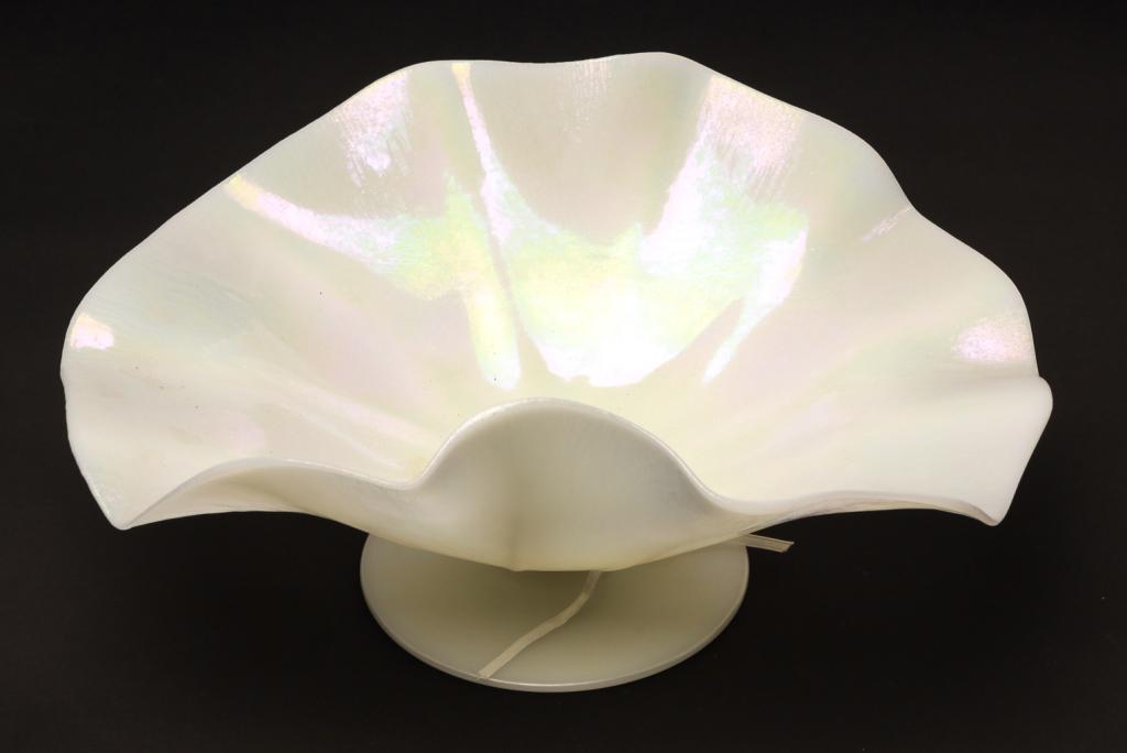 UNSIGNED STUEBEN IVORINE CONSOLE BOWL.: American, 1st quarter 20th century. White opaline glass with stretch iridizing, ruffled rim, and applied foot. Unground pontil. 6"h. 13.75"w. 11"d.