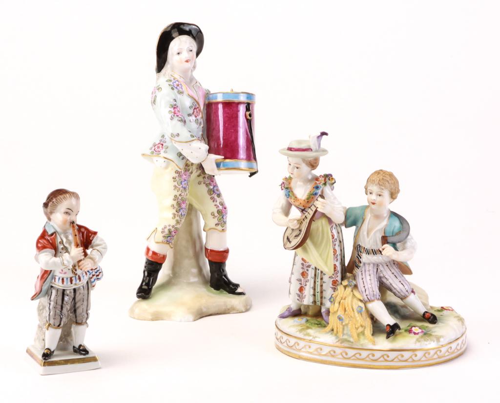 THREE GERMAN PORCELAIN FIGURINES.: 19th century. Sitzendorf of a boy playing a flute, 4"h. Boy and girl with lute and cobalt crown mark, 5.25"h. And man with drum-shaped instrument and crossed swords mark, E&C, 7"h. Two have damage.