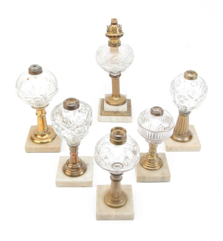 SIX FLINT PATTERN GLASS LAMPS ON MARBLE BASES.: American, mid 19th century. Two "Bull's-eye and Fluer De Lis" pattern, 9.5"h. "Ribbed Flowers" on stepped, marble base, 11"h. "Bull's-eye" variant,, 9"h. Ribbed with Gothic Arches, 7.75"h. And pattern