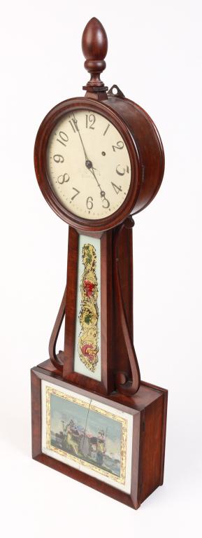 AMERICAN BANJO CLOCK.: Second quarter 19th century, mahogany and mahogany veneer with pine secondary. Turned finial, scrolled brackets, reverse painted tablets of which lower is cracked, painted sheet metal face, brass work