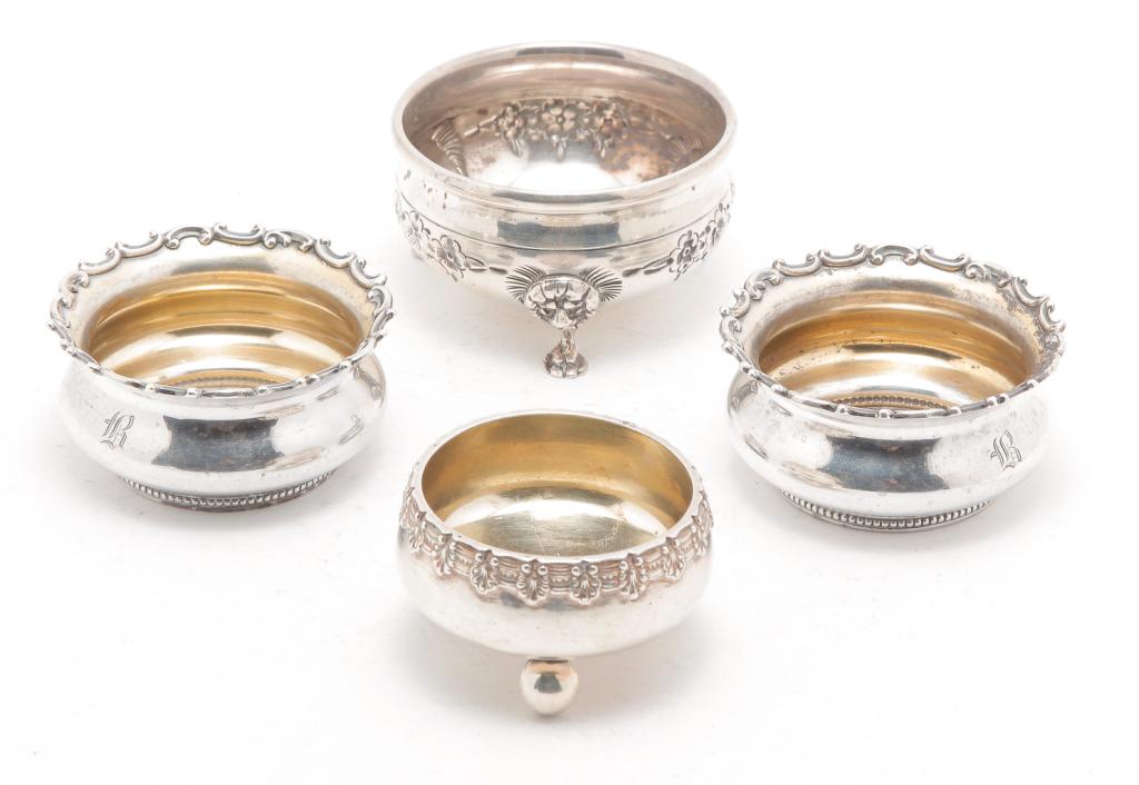 FOUR AMERICAN "STERLING" SALTS.: Late 19th-20th century. Single with ball feet by "Tiffany & Co.", 1"h. 2"d., pair with cast rims marked for Gorham, 1.25"h. 2.5"d. and a single with lion head and paw feet "B&M", 1.5"h. 2.5"d. Approx.