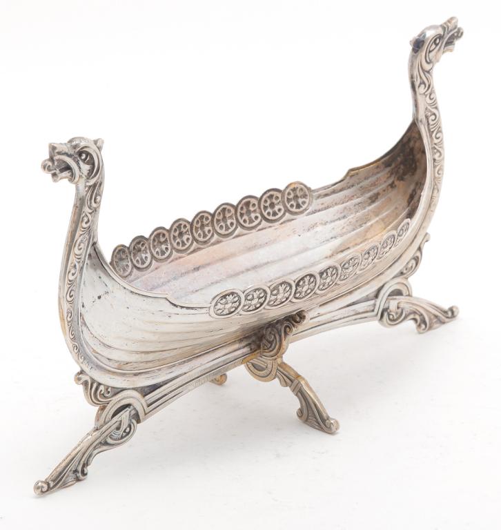 EUROPEAN SILVER VIKING SHIP SHAPED BOWL.: Twentieth century. Unmarked, possibly silver plate. Dragon headed ship on cross base. 5"h. 9"l.