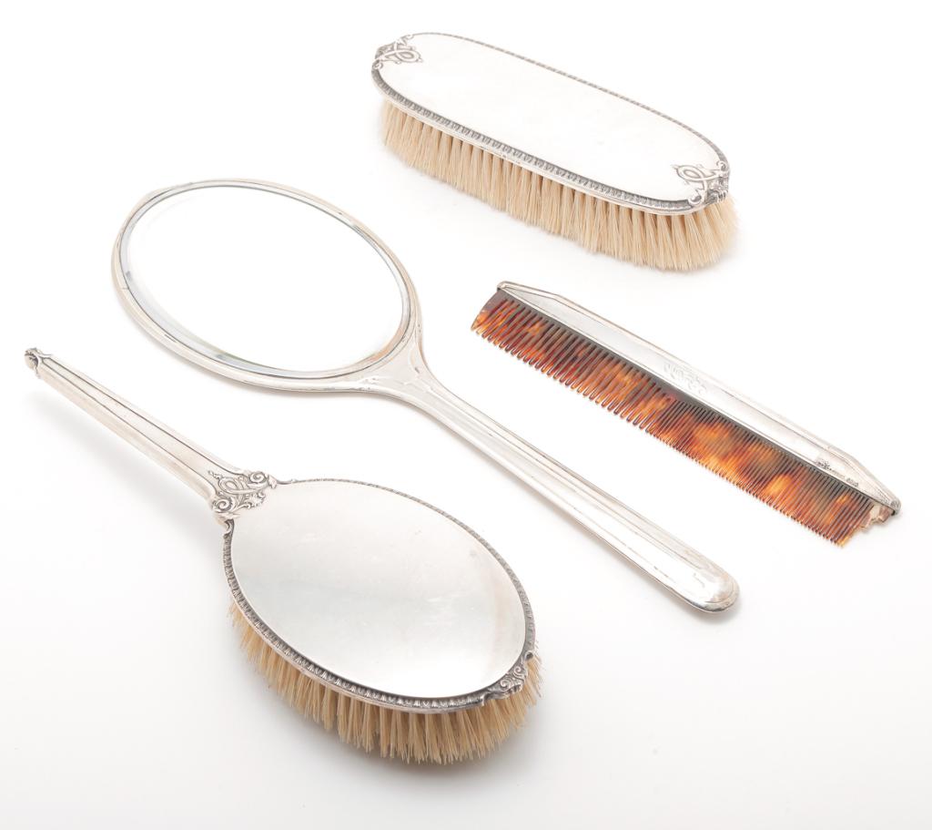 FOUR AMERICAN "STERLING" DRESSER PIECES.: First quarter 20th century. Hand mirror. Wear, no maker mark, 13"l., two matching brushes by International and a comb marked for R. Wallace. Sterling backs, comb has monogram.