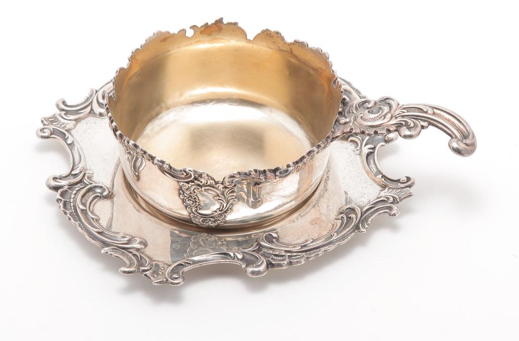 AMERICAN "STERLING" SAUCE POT BY REDLICH.: First half 20th century. Marked on the bottom for Redlich & Co. Vermeil interior and cast handle. 1"h. 5"l. Together with separate under tray with retail mark "Shreve, Crump & Lowe, San Francisco". Ap
