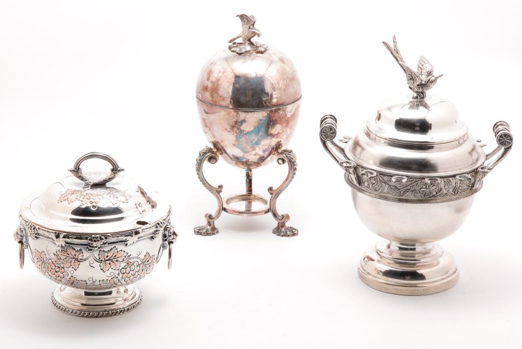 THREE SILVERPLATE SERVING PIECES.: American and English, late 19th-20th century. Covered sugar with spoon holders and bird finial. "Empire Mfg. Co., Quadruple Plate", 10"h., covered jelly bowl with grape vines, "Made in England", 6"h. 
