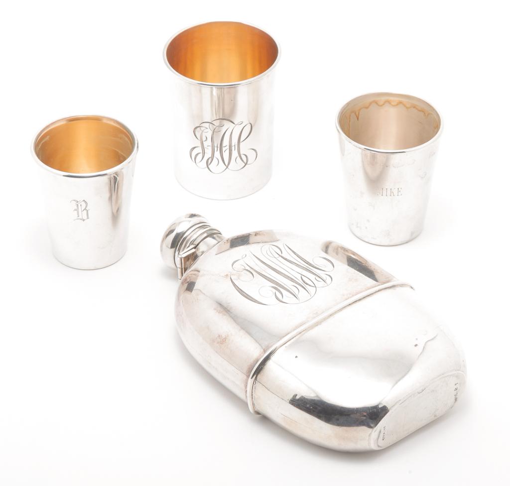 AMERICAN STERLING FLASK AND THREE TASTERS.: Late 19th-20th century. Sterling enclosed glass hip flask with removable bottom sterling cup. 6.25"h., a tumbler marked for International, 2.75"h., approx. 1.8 ozt. And two Reed & Barton sterling case