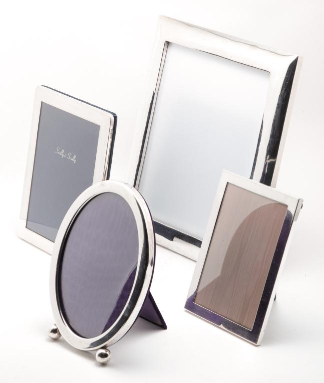 FOUR SILVER FRAMES.: Mid 20th century. English silver with London hallmarks, 8.5"h. 6.5"w., "Sanborn's Mexico Sterling" 11.75"h. 10.25"w. and two American "sterling" frames. Oval with illegible mark, 8"h. 6"w. and one by