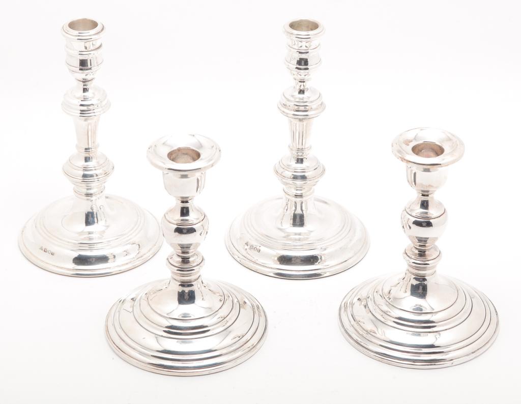 TWO PAIR OF SILVER CANDLESTICKS.: Second half 20th century. Weighted bases. English with London 1986 hallmarks, maker's mark "JAC", 7.5"h. and American "Sterling" marked for Redlich (most likely the mark used after Elgin took over the