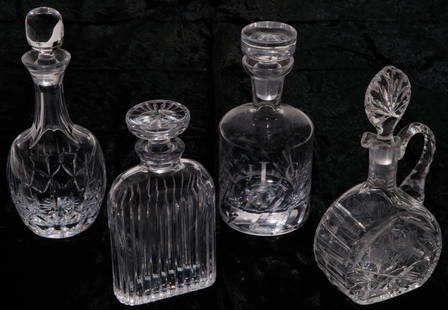 FOUR AMERICAN GLASS DECANTERS.: Second half 20th century. Fluted, 9.5"h., handled with etched grapes, 10.5"h., paneled neck, 10.25"h. and "Ravenscroft" by "Crystalize". 9.75"h.