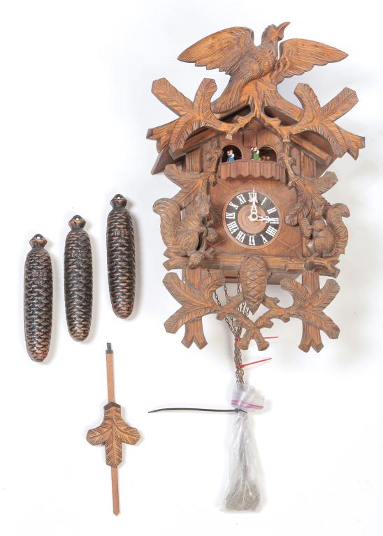 GERMAN BLACK FOREST CUCKOO CLOCK.: Second half 20th century. Case has carved squirrels, bird, pine cones and foliage. Dancing coupled on balcony. Three weights. Brass works marked "Made in Germany". 20.5"h. 14"w. 8.5"d.