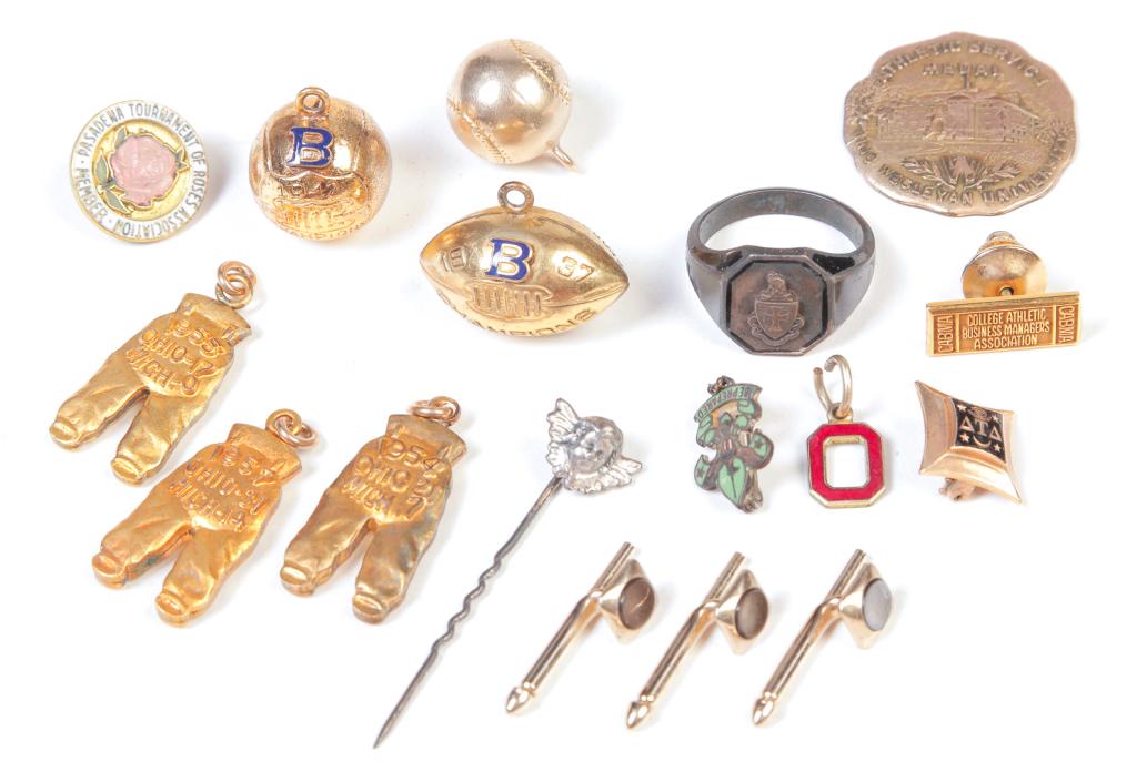 OHIO STATE BUCKEYES FOOTBALL "GOLD PANTS" CHARMS.: 20th century. Three desirable "gold pants" charms: OSU over Michigan 1954, 1955, and 1957. One pair engraved "GS" on the knee pads. Together with misc. sports related charms/pins and more; including 1