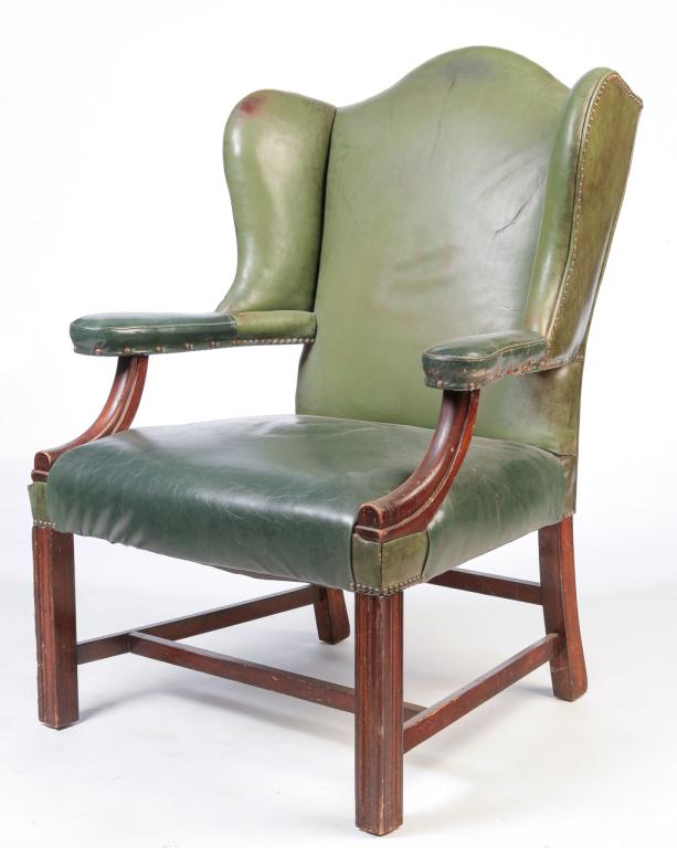 AMERICAN CHIPPENDALE STYLE WINGBACK CHAIR.: Mid 20th century, mahogany. Open arms, square legs with fluting, "H" stretcher, green leather upholstery with brass tack decoration. 17" seat. 42"h.