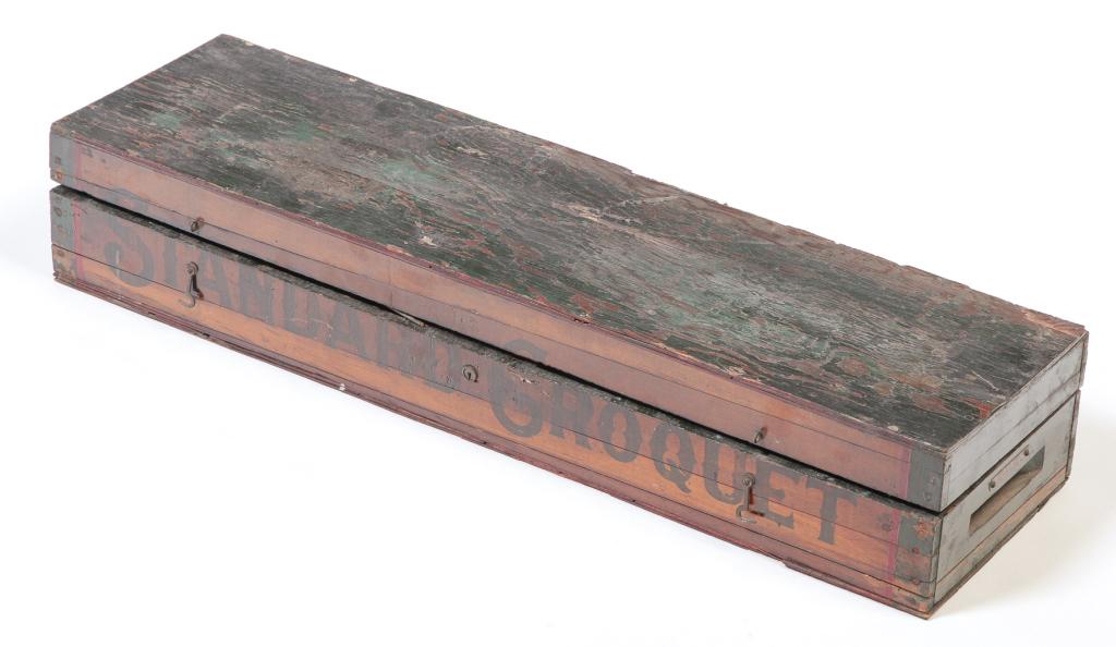 AMERICAN BOXED CROQUET SET.: First half 20th century. Pine and plywood case with worn green paint and stenciled label "Standard Croquet" with four mallets, two stakes, six balls and seven wickets. 5.25"h. 31.5"w. 8.75"d.