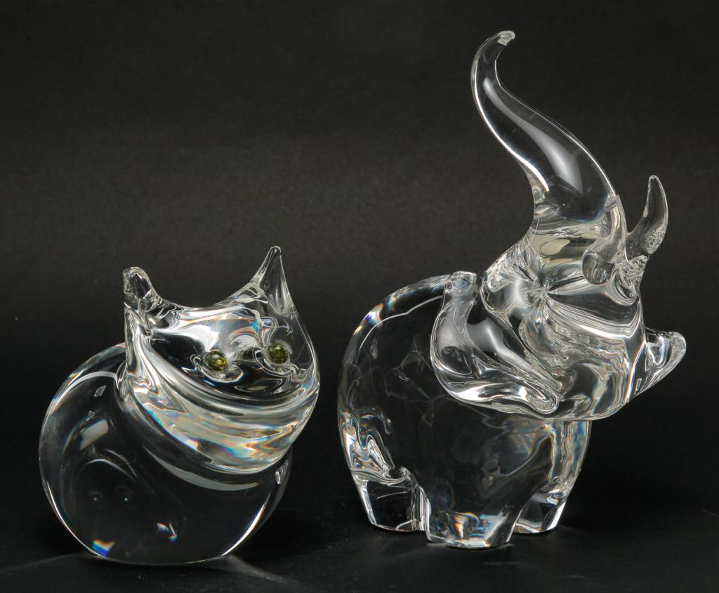 TWO AMERICAN STEUBEN CRYSTAL ANIMALS.: Late 20th century. Both diamond point signed. Cat with green eyes, 4.5"h. And an elephant with raised trunk. One tusk is chipped, 7.5"h.