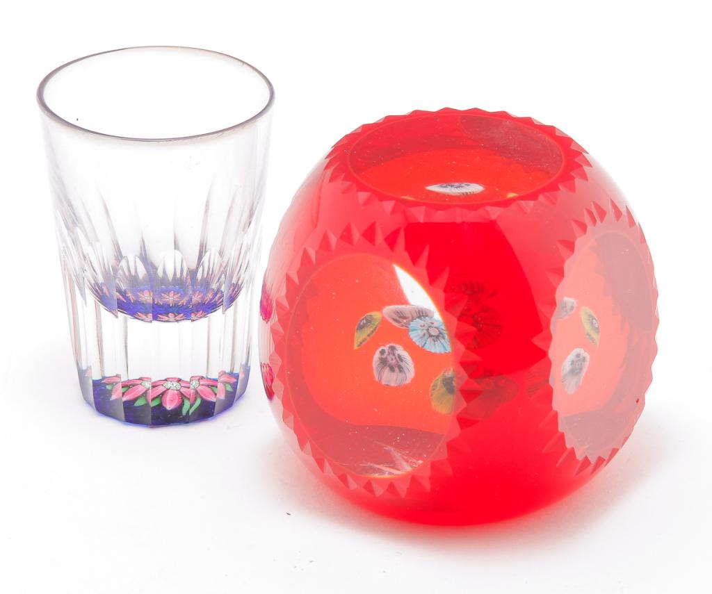 TWO EUROPEAN PAPERWEIGHTS.: Fourth quarter 20th century. Perthshire shot glass with paperweight bottom, blue interior with coral colored flowers, center one having "P" cane, cut fluting on sides and original label. 2.75"h. And a