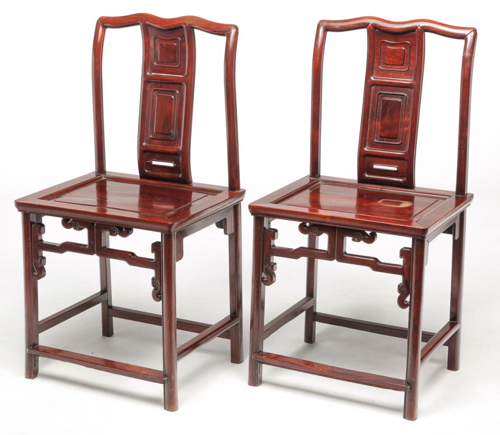 PAIR OF CHINESE OFFICIAL'S CHAIRS.: First quarter 20th century, elm. Reddish refinishing. Stylized yoke crests, paneled splats and seats with carved open aprons and stretcher bases. Water stain on one seat. 20" seat, 38"h.