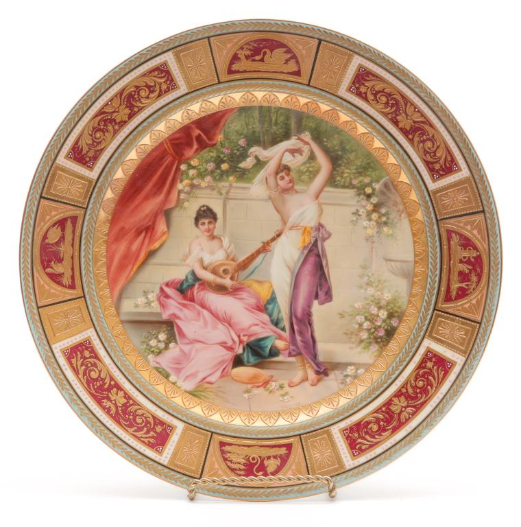 AUSTRIAN DECORATED PLATE.: Late 19th-early century. Royal Vienna plate with diaphanously-dressed muse "Terpsichore" in garden. Signed Wagner. Heavy gold border with maroon reserves with scenic and floral decoration. Cobalt beeh