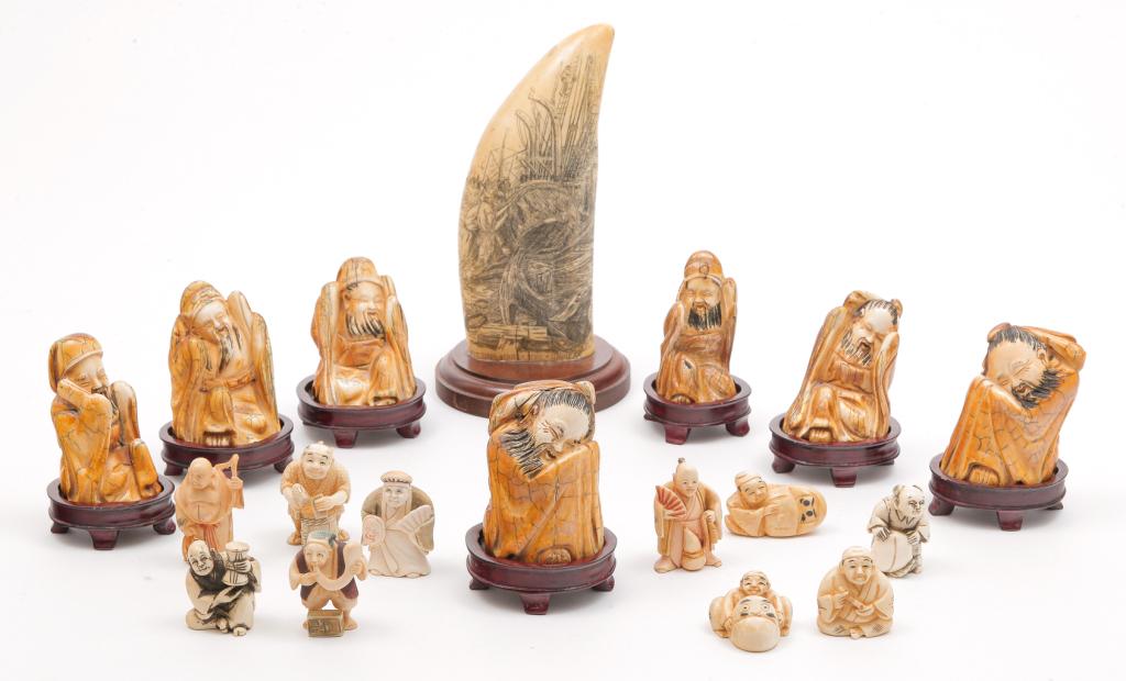 GROUP OF COMPOSITION PIECES.: Late 20th century. Scrimshaw tooth with sailing scene "Fitting out the Sunbeam", 6"h. and sixteen Asian figures. Six robed figures on teak stands, approx. 6"h. and ten netsukes of men in different voc
