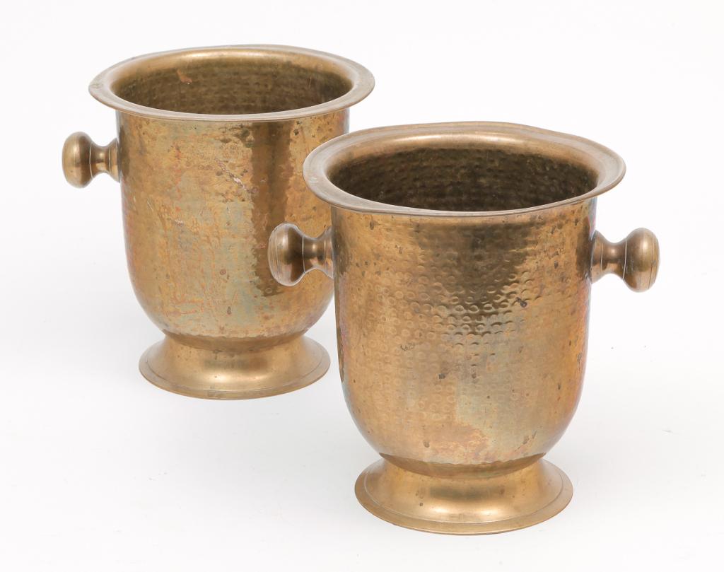 PAIR OF HAMMERED BRASS WINE COOLERS.: Second half 20th century. Knob handles and round foot. Ex Siegfried and Roy, Las Vegas. Dents. 9"h. From the Collection of Maxine and Dave Tronnes, Mitchell, South Dakota.