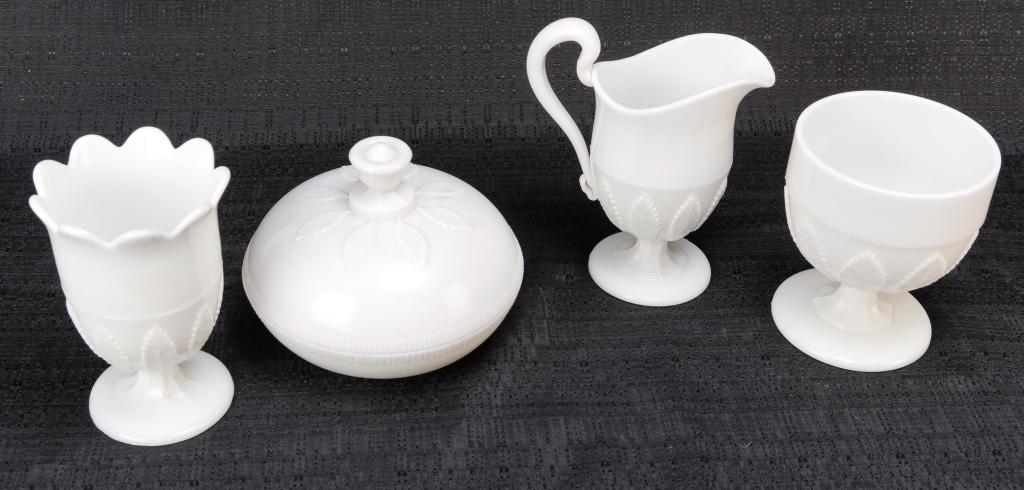 FOUR PIECES OF AMERICAN BIRCH LEAF MILK GLASS.: Mid 19th century. Slightly opalescent. Creamer with applied handle, 6.25"h., spooner, 5.5"h., buttermilk goblet, 5"h. and a lidded butter dish, 4.75"h.