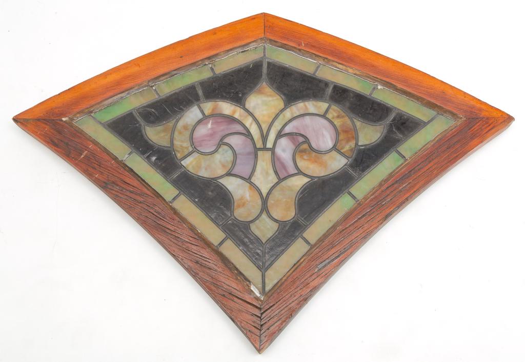 AMERICAN COLORED AND LEADED GLASS WINDOW.: Ca. 1900, pine frame. Green, pink and tan slag and textured amber glass. Probably from the top of a gothic arched window. Some cracks. 26"h. 36.5"w.