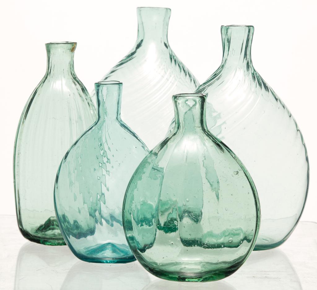 FIVE MIDWESTERN BLOWN GLASS FLASKS.: Including Ohio examples, 2nd quarter-19th century. The first a pale green with twenty four swirl ribs, 6.5"h.; aqua with eighteen swirl ribs, 6.25"h.; twenty four swirl rib aqua pocket flask, 5"h.; si