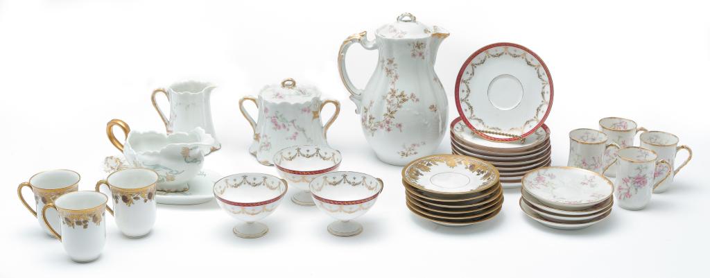 GROUP OF FRENCH PORCELAIN.: Ca. 1900. Six "LS & S Limoges chocolate cups and saucers with gold floral decoration, nine pedestal tea cups and saucers with maroon borders and gold swags by "C. Ahrenfeldt, Limoges" and eight pieces