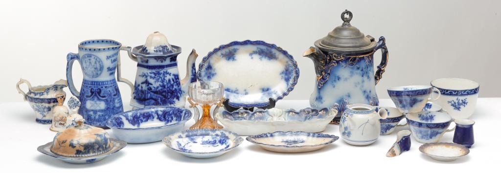 LARGE GROUP OF FLOW BLUE ETC.: Late 19th century. "Touraine" pattern mostly with others added in. Some souvenir pieces etc. Stains and damage throughout.