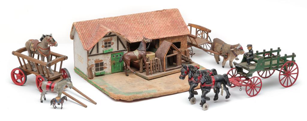 EUROPEAN TOY FARM STEAD WITH ANIMALS.: Twentieth century. Composition and cardboard farmyard with buildings and two non related sheds, one marked "Germany". 6.5"h. 14"w. 13"d. Together with two carts, one pulled by a composition cow, 11", 