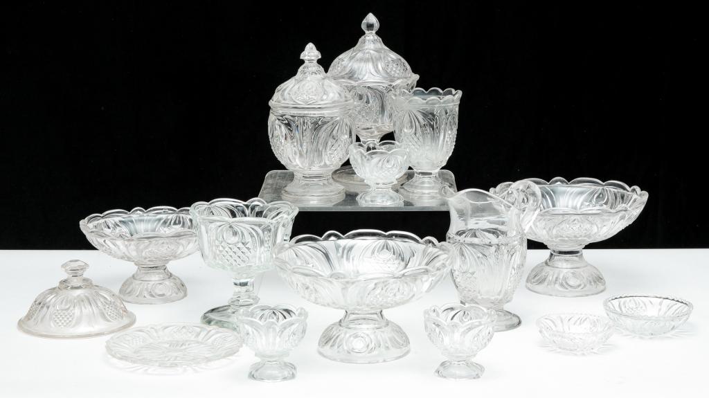 GROUP OF "NEW ENGLAND PINEAPPLE" GLASS.: American, mid 19th century. Clear flint glass pattern by Boston & Sandwich Glass Co. Approx. twenty five pieces including two lidded sugar bowls, creamer (heat check in handle), three open compotes, s