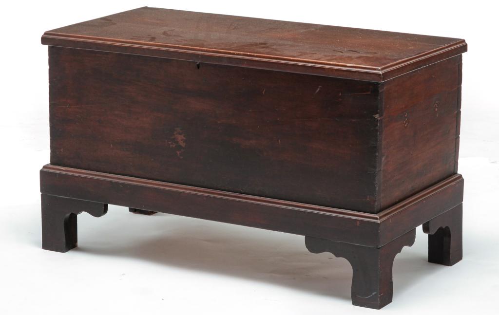 AMERICAN DIMINUTIVE BLANKET CHEST.: Mid 19th century, cherry with pine secondary. Lid with applied edge molding, dovetailed case, high bracket feet are replacements, and an interior till. Edge damage, refinished. 21"h. 35"w. 17.25"d.