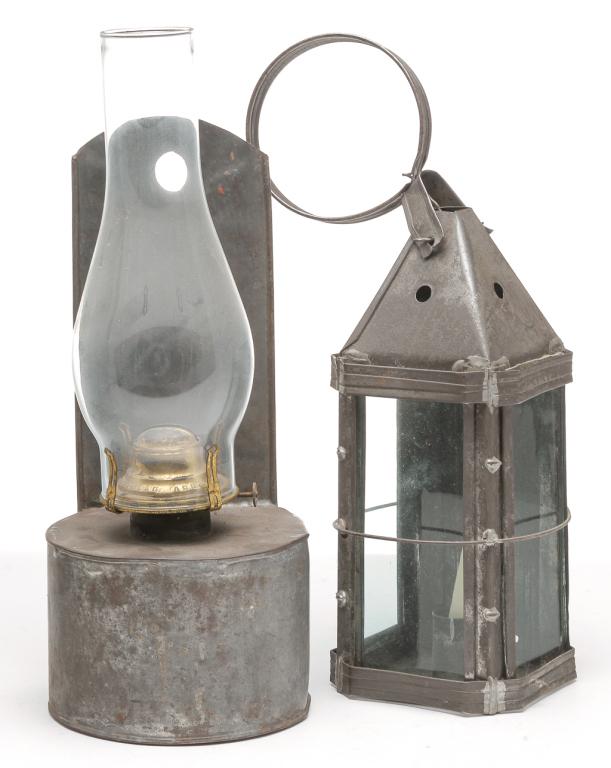 TWO PIECES OF AMERICAN TIN LIGHTING.: Second half 19th century. Candle lantern with ring handle, three glass sides and wire cage (two missing), and sliding back panel. 15.5"h. and a kerosene wall mount lamp with rounded font and back with