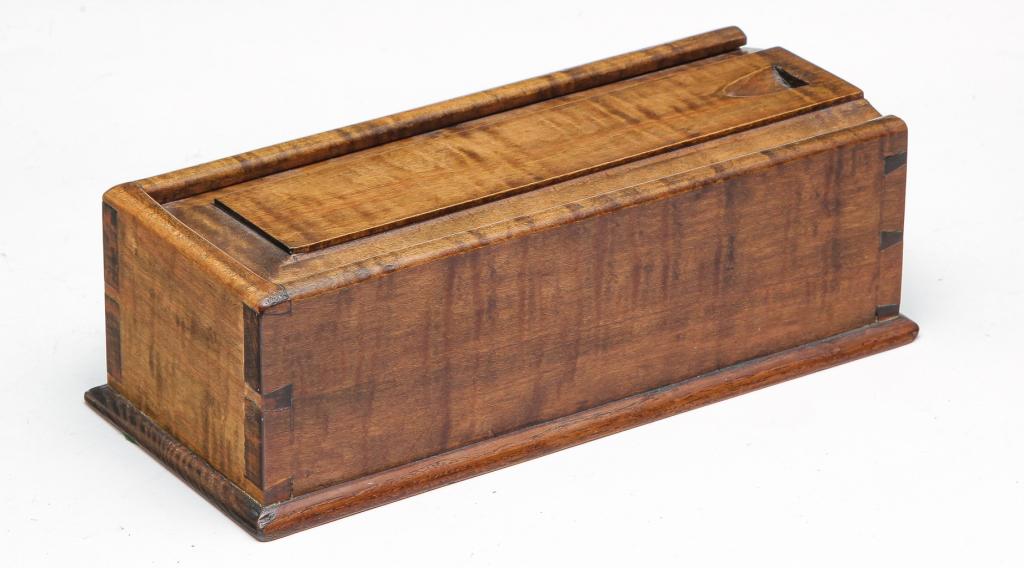 BERNIE HARTER SLIDE LID CANDLE BOX.: Fourth quarter 20th century. Tiger maple. Harter, from Canton, Ohio, dovetailed case and raised panel lid, 3.25"h. 10.25"w. 4.5"d.