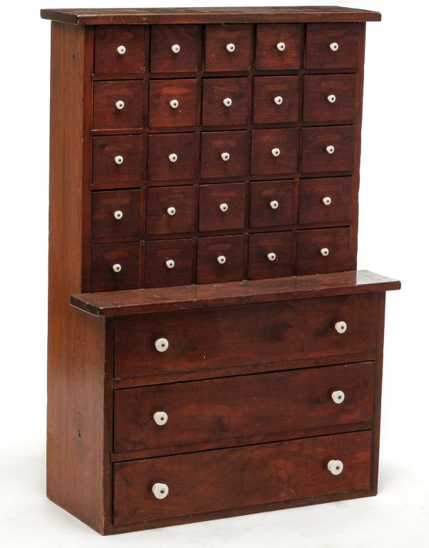 AMERICAN CHILDS' SIZE APOTHECARY CABINET.: Late 19th century. Walnut with pine secondary. Stepback: top with 25 drawers, waist shelf and three lower drawers. Refinished. 48"h. 32.5"w. 14"d.
