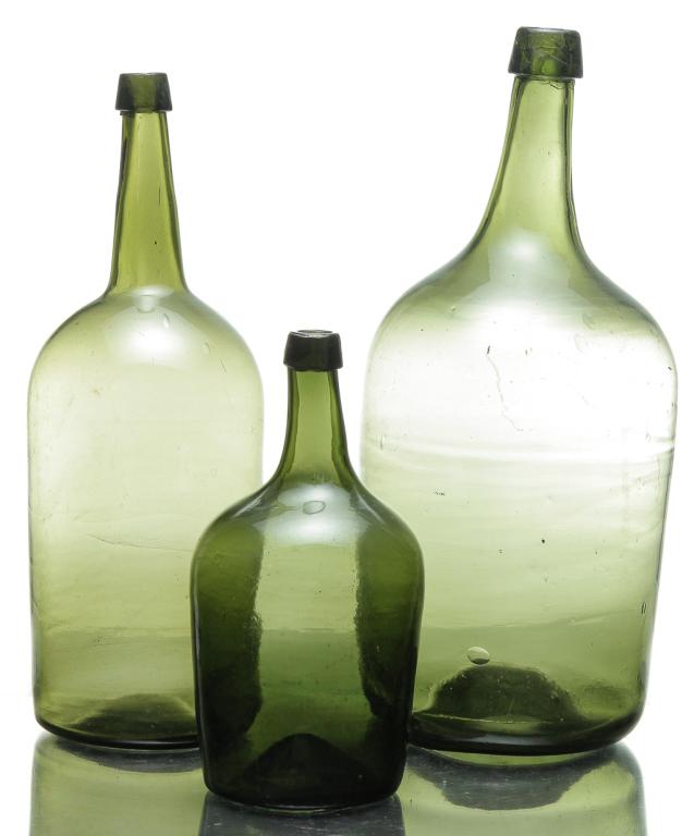 THREE EUROPEAN DEMIJOHNS.: Mid 19th century. Olive green with blob tops. Largest has broken pontil. 18.5"h. and two are smaller, blown from the top down. 11", 17"h.