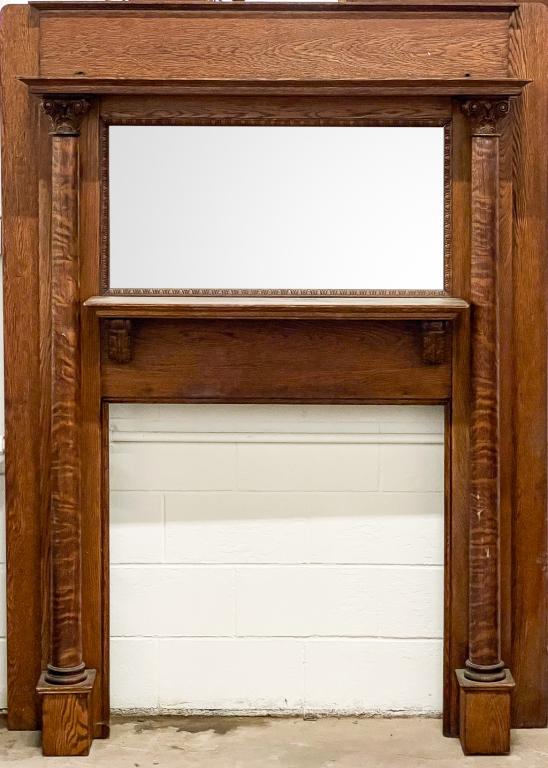 AMERICAN QUARTER SAWN AND OAK MANTEL.: Ca. 1900. High back with top shelf supported by free standing columns with Corinthian capitals,, beveled mirror with egg molding trim and lower shelf with carved brackets. 78.75"h. 59"w. 12"d. Opening