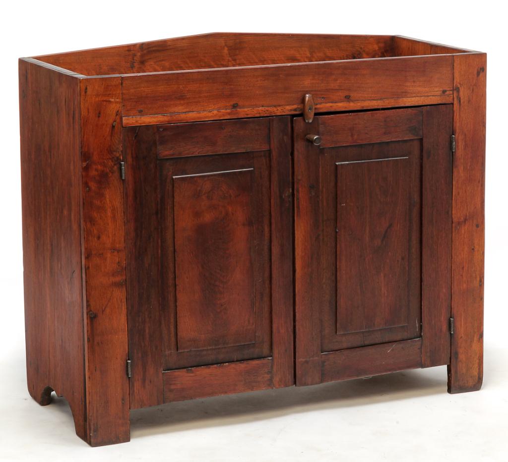 AMERICAN COUNTRY DRY SINK.: Mid 19th century. Walnut with ash secondary. Peaked back splash, simple cut out ends and two raised, single-panel doors. Refinished. 36"h. 42.25"w. 17.75"d.
