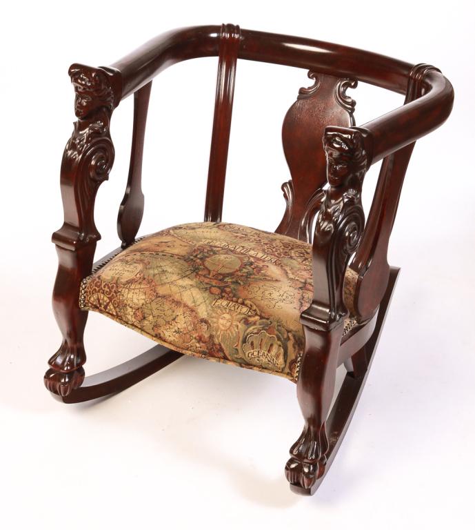 ASIAN BARREL BACK ROCKER.: Late 20th century, mahogany. Executed in the American ca. 1900 style, vase back, lady's heads raised on scrolled arm stiles and hairy paw feet. Upholstered seat with brass tack trim. 16" seat, 30"h.