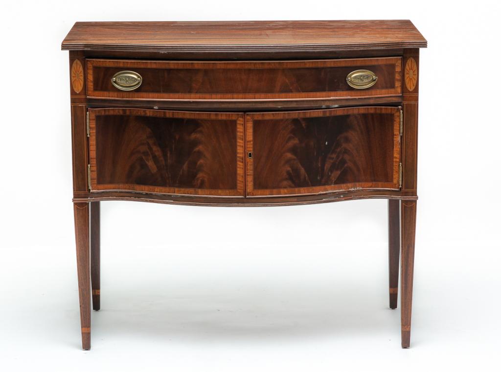 AMERICAN HEPPLEWHITE STYLE SIDEBOARD.: Mid 20th century, mahogany. Small size with bowfront, top reeded edge, dovetailed drawer over two doors, square tapered legs and banded, line and fan inlays. 35"h. 39"w. 19.5"d.