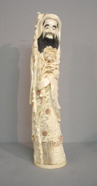 ORIENTAL IVORY CARVING. Scholar in a robe carrying: ORIENTAL IVORY CARVING. Scholar in a robe carrying a staff and large flower. Incised details with red, black and green ink. Signature cartouche on the bottom. 14"h.