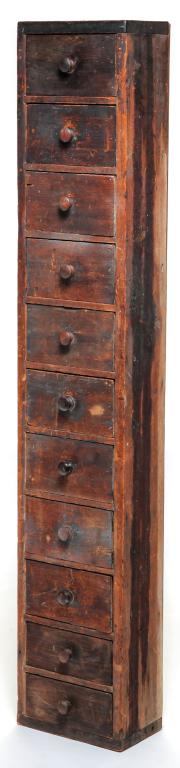 AMERICAN COUNTRY CASE OF DRAWERS.: Mid 19th century, pine. Eleven drawers with turned knobs. Square nail construction. Replaced back. Ex. Jeff Walton. 51.5"h. 9.5"w. 6''d.