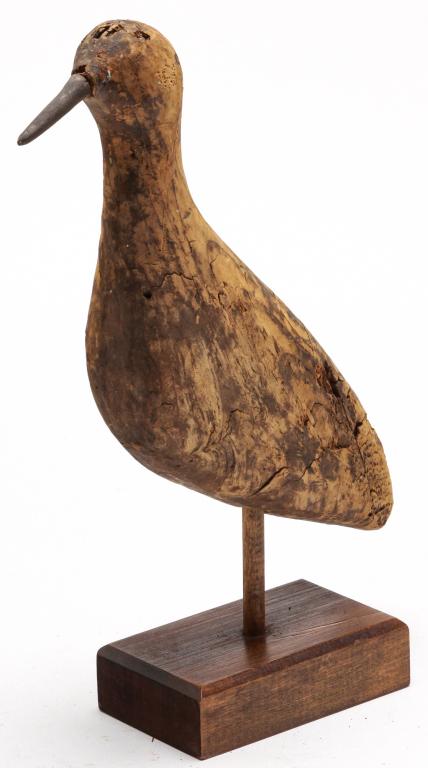 AMERICAN CARVED SHOREBIRD.: Late 20th century, pine. Weathered and distressed carving on base signed "Gregory C. Tet_, 1983". 13"h. overall.