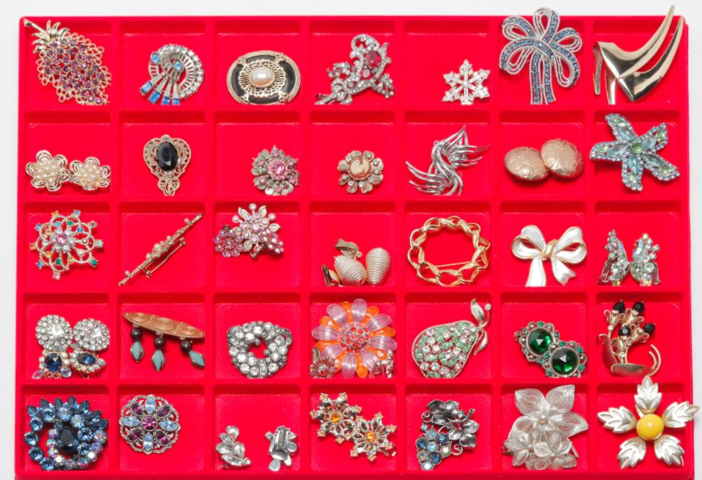 CROSS SECTION OF 20TH CENTURY BROOCHES & EARRINGS.: Mid-late 20th century. Forty pieces of costume jewelry representing a range of styles. Brooches and earrings in silver and gold tones, some with rhinestones, enamel and other materials. Several sets i