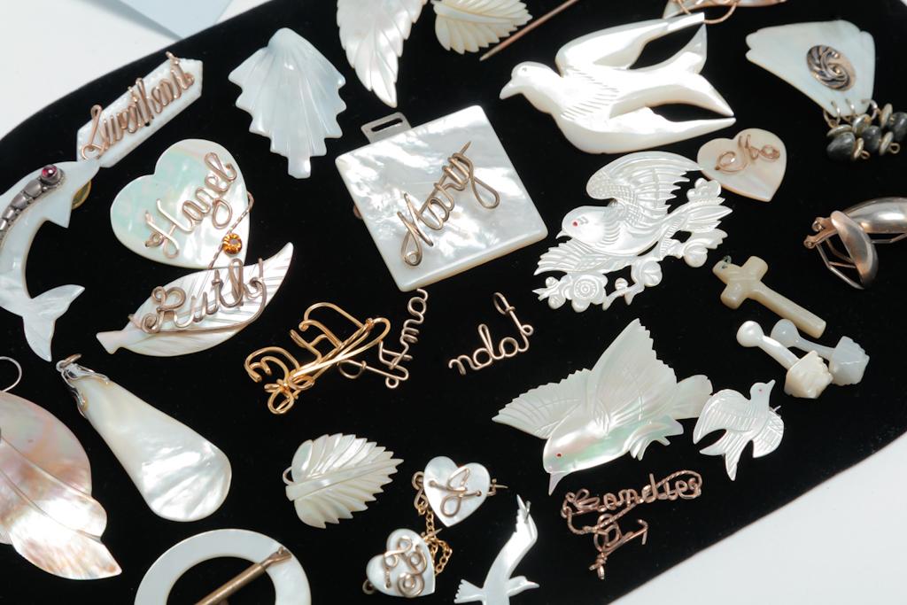WWII ERA MOTHER-OF-PEARL JEWELRY AND MORE.: Mid-late 20th century. Sweet group of jewelry from WWII including small pins made of mother-of-pearl - several with wire spelling out Sweetheart, Hazel, Doris and others. Some with only the wire name.