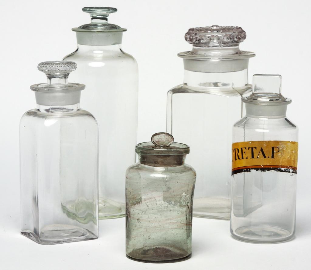 SEVEN AMERICAN CLEAR GLASS JARS.: Second half 19th century. Apothecary jars, one with label. 9"h. and 12"h. Three square canister jars, 11.5" and 11"h. Square 9.5"h. And greyish tint 6.5"h.