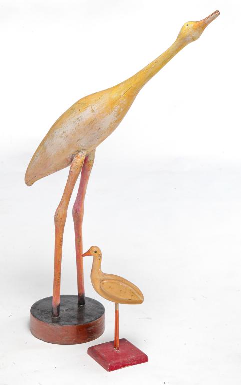 TWO AMERICAN FOLK ART CARVED CRANES.: Second half 20th century, mixed wood. Original paint. Larger is later and has "LH" scratch carved into underside. Some flaking and splits. 32"h. Smaller has alligatored paint and "CK" marked on unders