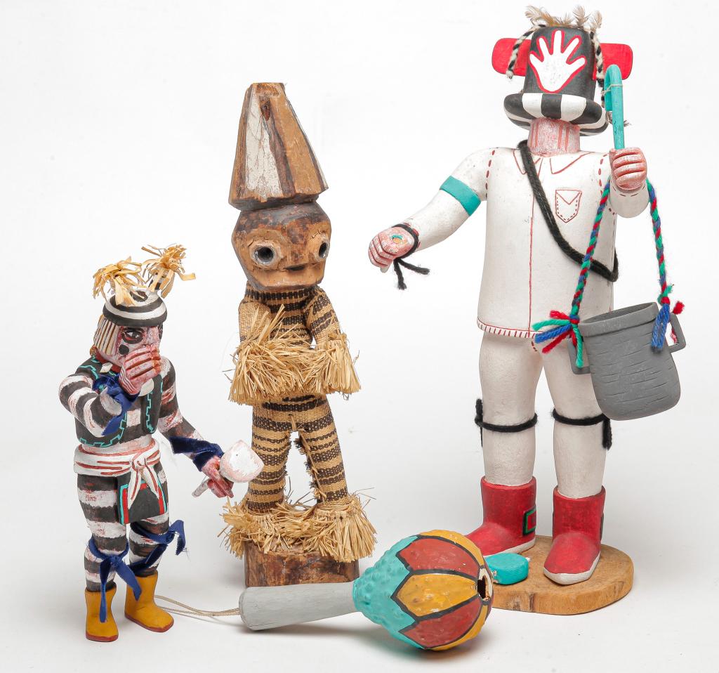THREE NATIVE AMERICAN KACHINAS AND A RATTLE.: Second half 20th century. Two traditional carved kachinas with original paint. Striped, 10"h. and a Potcarrier signed and titled on bottom "Randall Ponyah, Potcarrier (Old Way), 2nd Mesa, Sivu-i-kil-t